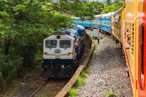 반대 방향으로 평행하게 달리는 두 개의 인도 철도 열차가 쾌적한 날에 서부 가츠의 구릉 지대에서 느린 속도로 서로 교차하고 있습니다. - 이미지 - travelogue 뉴스 사진 이미지