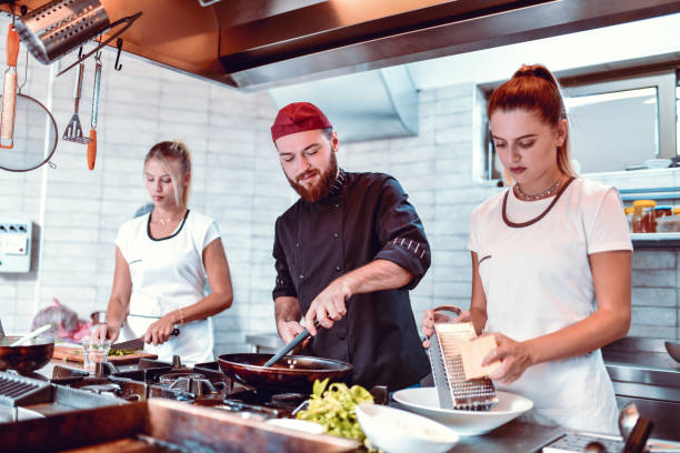 istock Male Chef Getting Good Help From Cute Female Kitchen Assistants 1224773271