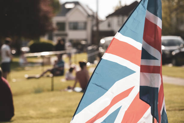 Vintage style Union Jack flag flying in front of VE Day celebrations at a social distance street party in May 2020 Vintage style Union Jack flag flying in front of VE Day celebrations at a social distance street party in May 2020 ve day celebrations uk stock pictures, royalty-free photos & images