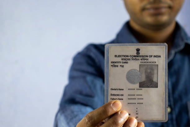 un homme indien avec le visage souriant retenant la carte d’électeur - soi bangla photos et images de collection