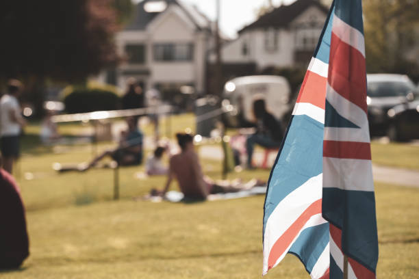 Vintage style Union Jack flag flying in front of VE Day celebrations at a social distance street party in May 2020 Vintage style Union Jack flag flying in front of VE Day celebrations at a social distance street party in May 2020 ve day celebrations uk stock pictures, royalty-free photos & images