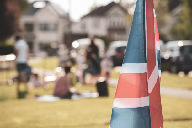 Vitage style Union Jack flag flying in front of VE Day celebrations at a social distance street party in May 2020 Vitage style Union Jack flag flying in front of VE Day celebrations at a social distance street party in May 2020 ve day celebrations uk stock pictures, royalty-free photos & images