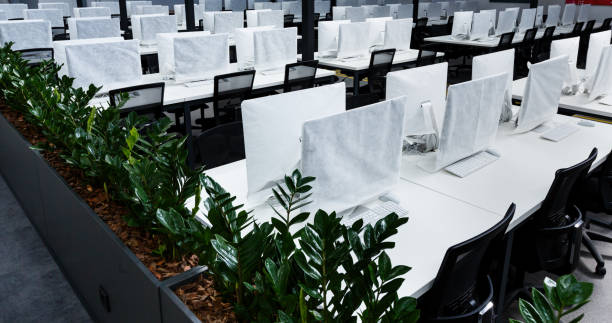 istock Wrapped in cover computers on workplaces with no people 1224774540