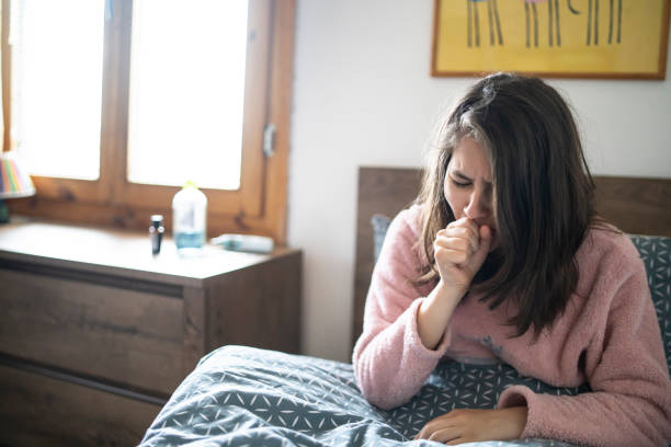 Ill teenage girl laying at home Ill teenage girl laying at home. Concept for ill nes and coronavirus symptoms coughing stock pictures, royalty-free photos & images