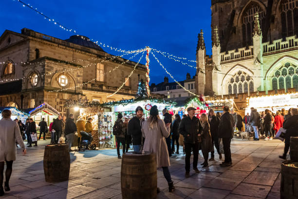 Christmas in Kingston Parade, Bath (England, UK) People at the Christmas market set up in Kingston Parade, at the foot of the Bath Abbey. bath abbey stock pictures, royalty-free photos & images