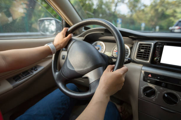 istock People hands holding steering wheel while driving car on city road 1224778185