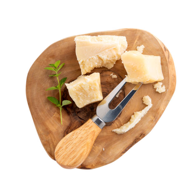 Piece of parmesan cheese on wooden board  isolated on white. Parmigiano Reggiano, hard mature cheese. Top view. Piece of parmesan cheese on wooden board  isolated on white. Parmigiano Reggiano, hard mature cheese. Top view. grana padano stock pictures, royalty-free photos & images