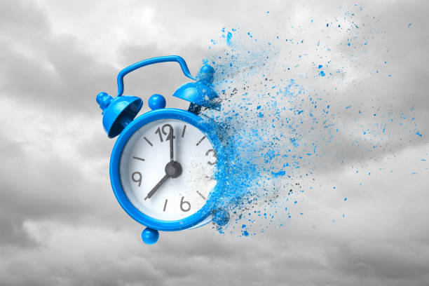 Time is running out Time is running out. Blue alarm clock waving like sand or ashes against background of clouds. dispelled stock pictures, royalty-free photos & images