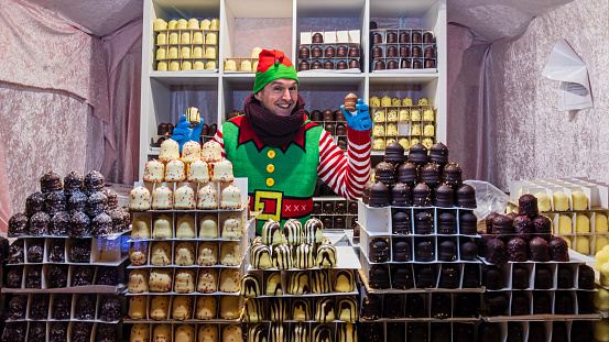 Santa's elf selling traditional chocolate kisses at the Christmas Market set up in the historic Broad Street of Oxford.