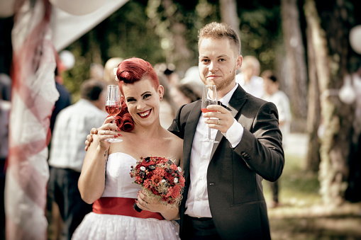 Portrait of Smiling Bride and Bridegroom With Drinks After Wedding Ceremony.