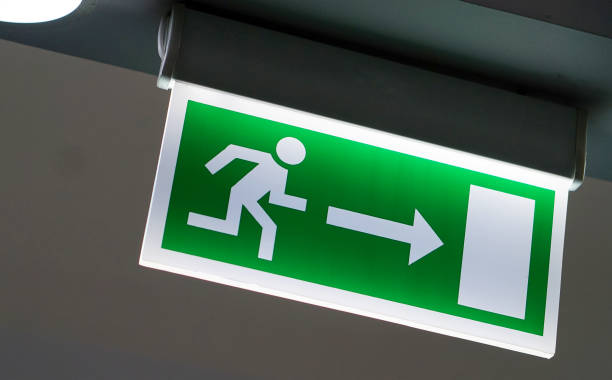 istock Close-up of electrical illuminated Fire Exit signage in a public place 1224782630