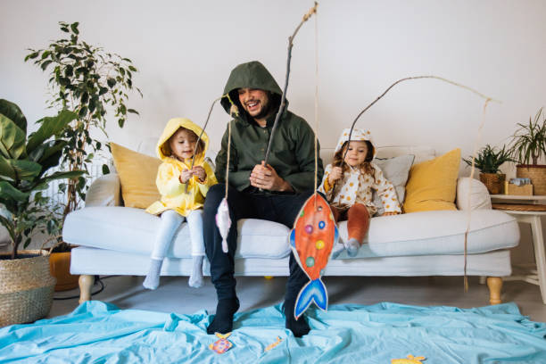 kinder mit vater spielen angeln zu hause - betätigung stock-fotos und bilder