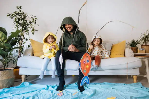 Happy child and young father with inflatable ring and drawing tropical fishes around him