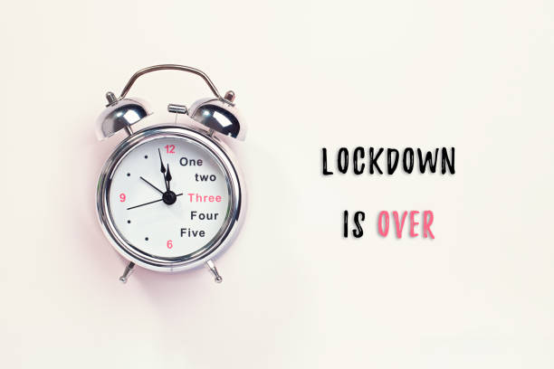 istock Alarm clock and text lockdown is over on pastel background. Creative flat lay, quarantine is over or back to normal life concept. When coronavirus lockdown ends theme 1224783710