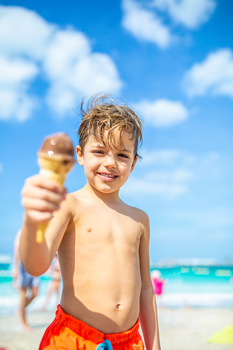 A Happy Boy Eating Ice Cream On The Beach Stock Photo