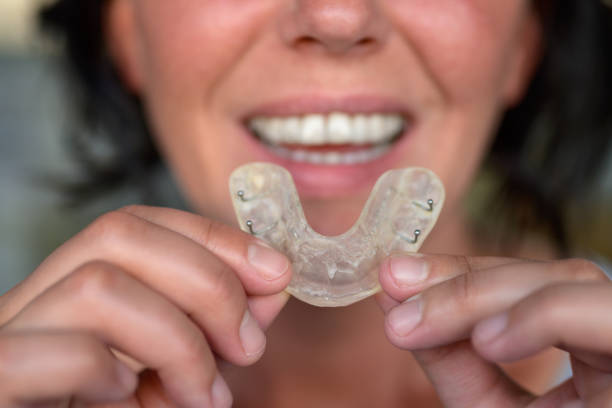 istock Woman suffering from bruxism holding up a guard 1224786304