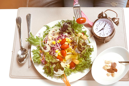 Alarm clock of Intermittent fasting and Healthy food and salad Concept.