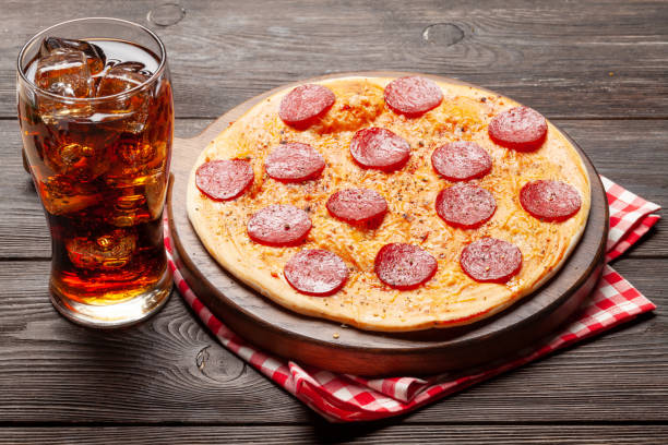 Tasty homemade pizza with pepperoni and glass of cola with ice