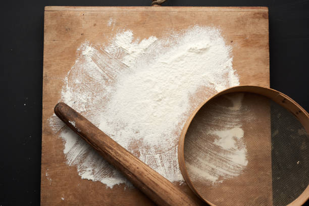 istock white wheat flour scattered on a black table and a wooden rolling pin 1224793548