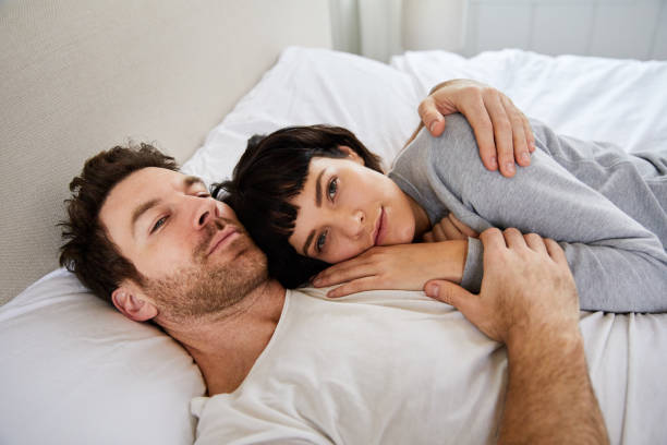 istock Young woman lying in bed with her head on her husband's chest 1224793664