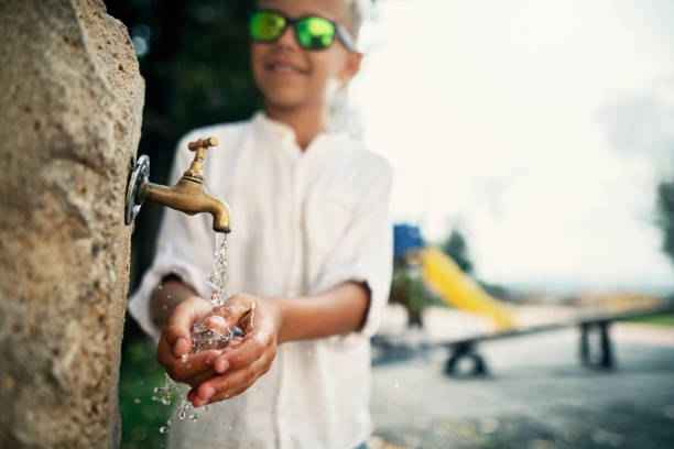 istock Little boy drinking water from public fountain 1224796322