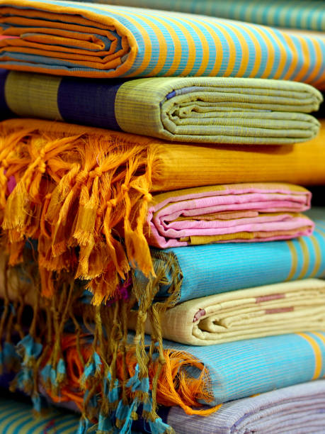 vista de cerca de las mujeres indias sarees o saris apilados en la exhibición de venta al por menor en una tienda - sari fotografías e imágenes de stock