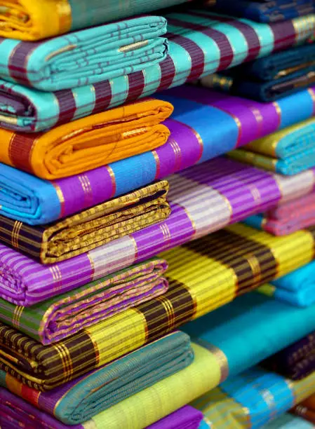 Indian woman sarees or saris stacked in retail display in a store