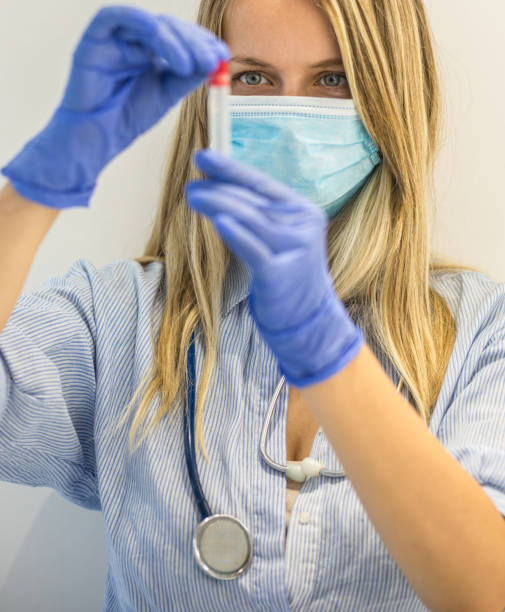 istock Nurse with mask holding test tube 1224800907