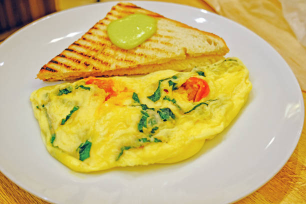 istock scrambled eggs omelette with fresh herbs tomatoes, basil, greek cheese, parmesan, toast and oregano and garlic panini toasts with wasabi closeup view 1224801823