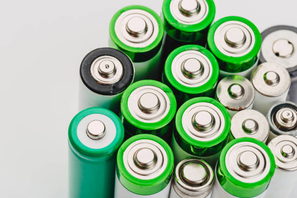 many new and used alkaline batteries type AA on a light background.