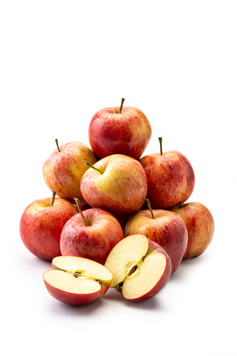 Pile of Fresh Apples on white background. One apple sliced.