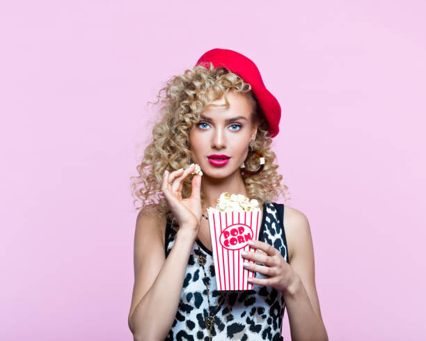 istock Pretty woman in 80's style clothes holding popcorn box 1224806905