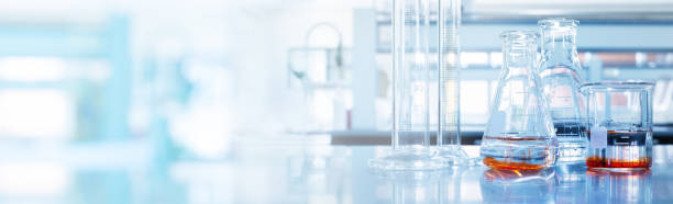 부드러운 청색 빛 의학 과학 실험실 배너 배경유리 플라스크 및 실린더에 물과 오렌지 솔루션 - 실험실 뉴스 사진 이미지