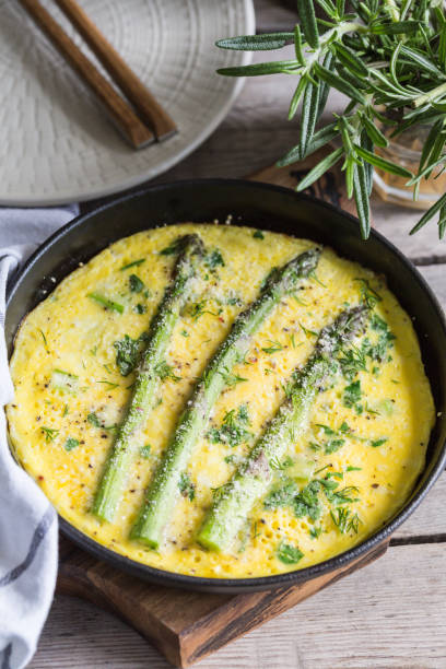 Asparagus with scrambled eggs. Omelet with asparagus  in a frying pan. stock photo
