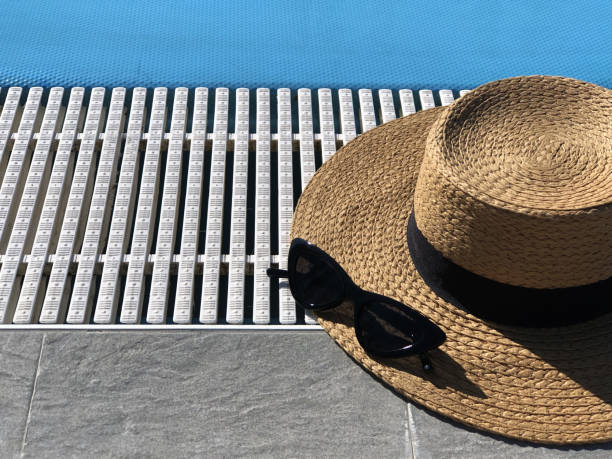 istock Straw hat and sunglasses along the poolside. Copy space. Summer concept. Sun protection. Beach style. Top view 1224807316