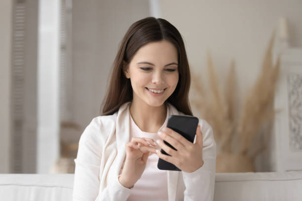 istock Smiling girl using messaging on modern smartphone 1224807888