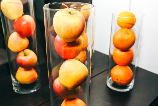 istock Fruit in glass vases standing on the table. apples and oranges in decorative interior design. Fresh vegetarian vitamins. 1224807973