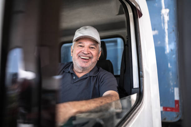 Portrait of a senior male truck driver sitting in cab Portrait of a senior male truck driver sitting in cab truck driver stock pictures, royalty-free photos & images