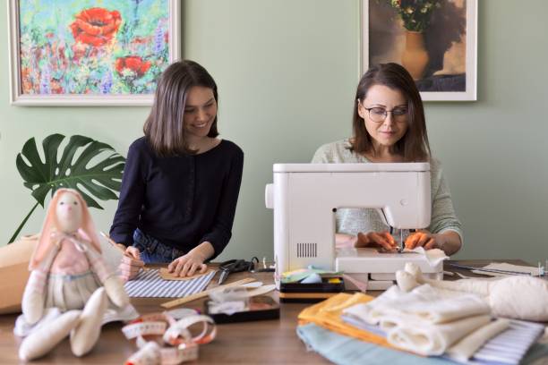 madre y adolescente hija coser juntos en casa - sewing women tailor teenage girls fotografías e imágenes de stock