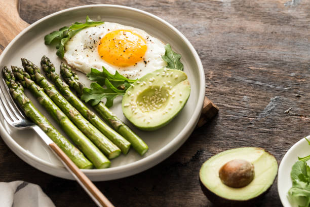 zdrowe domowe śniadanie ze szparagami, jajkiem sadzonym, awokado i rukolą. kwarantanny koncepcji zdrowego odżywiania. dieta keto - arugula cooked spice lettuce zdjęcia i obrazy z banku zdjęć