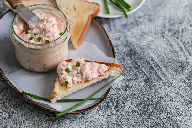 lachs und weicher cremekäse im glas aufgestrichen. lachsrilletten, mousse, pastete und toasts auf grauem hintergrund - canape appetizer gourmet salmon stock-fotos und bilder