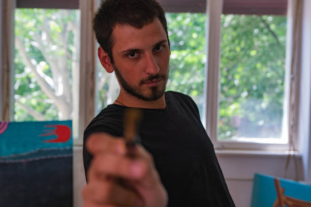 istock Young man holding a brush to the camera 1224811127