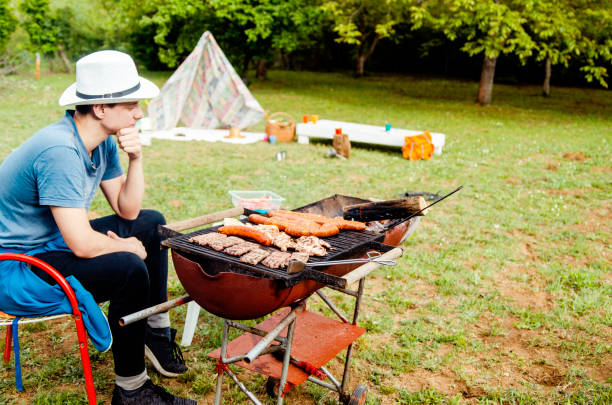 istock Backpacker Man preparing barbecue outdoors 1224811800