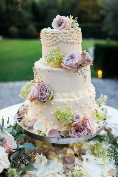 istock Wedding cake standing on the table. Around the flowers. 1224818195