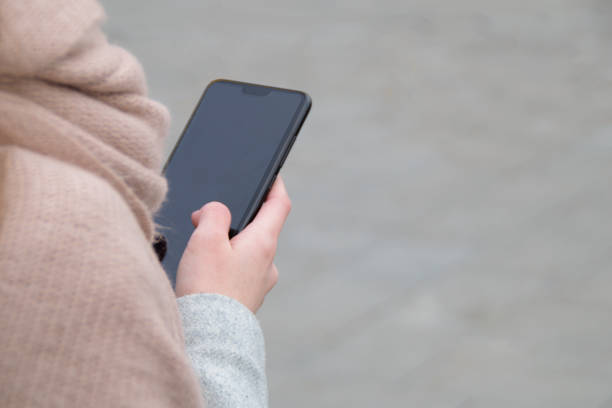istock The woman hand holds a smart phone - view over his shoulder. Negative space. Copy space for text. 1224821475