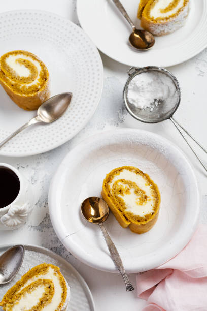 istock Dessert pumpkin roll with butter cream and orange on a light gray bnton background. Selective focus. 1224822237