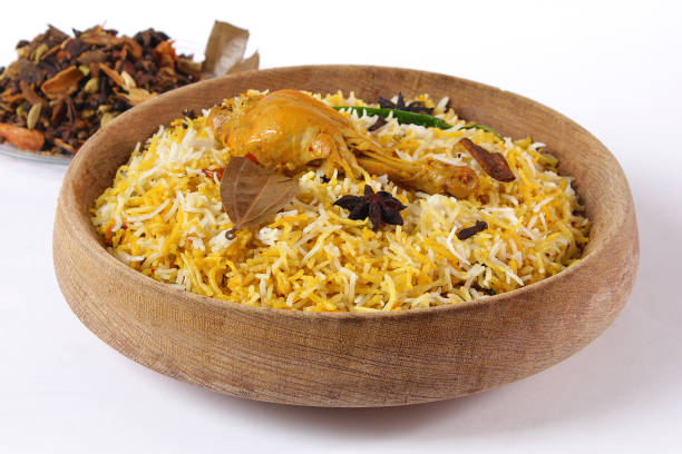 Delicious spicy chicken biryani in traditional bowl on White background, Indian or Pakistani famous masala rice food. Potato and meat are main ingredients of this recipe | Best Ramadan iftar meal.