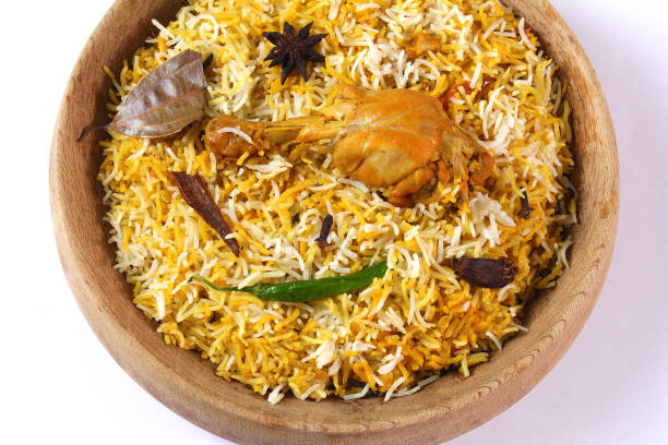 Delicious spicy chicken biryani in traditional bowl on White background, Indian or Pakistani famous masala rice food. Potato and meat are main ingredients of this recipe | Best Ramadan iftar meal.