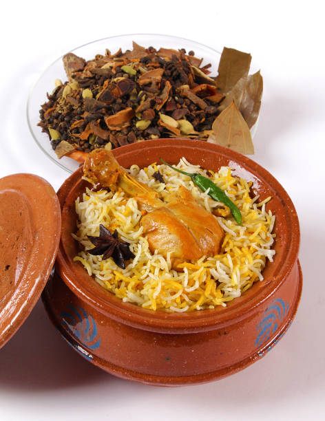 Delicious spicy chicken biryani in traditional bowl on White background, Indian or Pakistani famous masala rice food. Potato and meat are main ingredients of this recipe | Best Ramadan iftar meal.