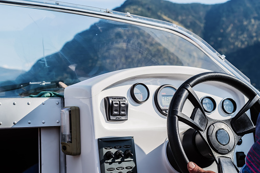 Steering wheel and dashboard of a pleasure boat. The view from the cab. Russia, Altai Republic, Lake Teletskoye